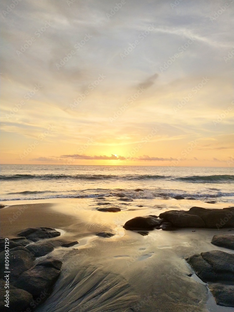 Yellow-orange sunset and sunrise on the ocean shore, Bali island. Epic sunrise, sandy beach. Landscape of Indonesia