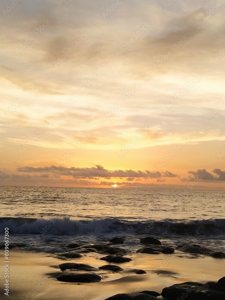 Yellow-orange sunset and sunrise on the ocean shore, Bali island. Epic sunrise, sandy beach. Landscape of Indonesia Yellow-orange sunset and sunrise on the ocean shore, Bali island. Epic sunrise, sandy beach. Landscape of Indonesia