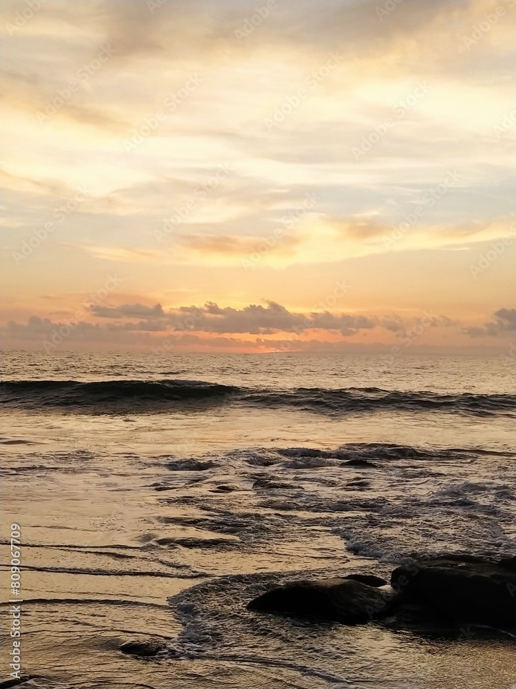 Yellow-orange sunset and sunrise on the ocean shore, Bali island. Epic sunrise, sandy beach. Landscape of Indonesia