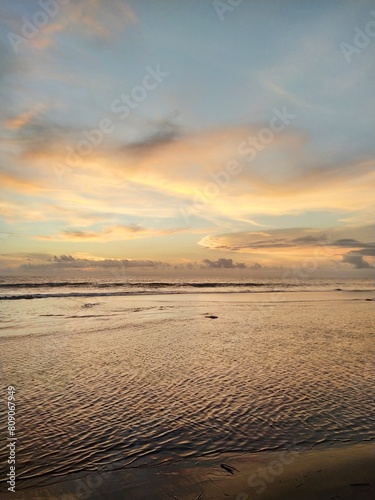 Yellow-orange sunset and sunrise on the ocean shore  Bali island. Epic sunrise  sandy beach. Landscape of Indonesia