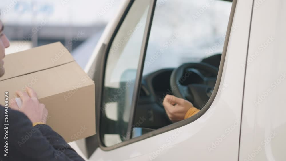 Male costumer collecting the package, paying it with a card from delivery man Male costumer collecting the package, paying it with a card from delivery man