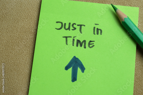 Concept of Just in Time write on sticky notes isolated on Wooden Table. photo