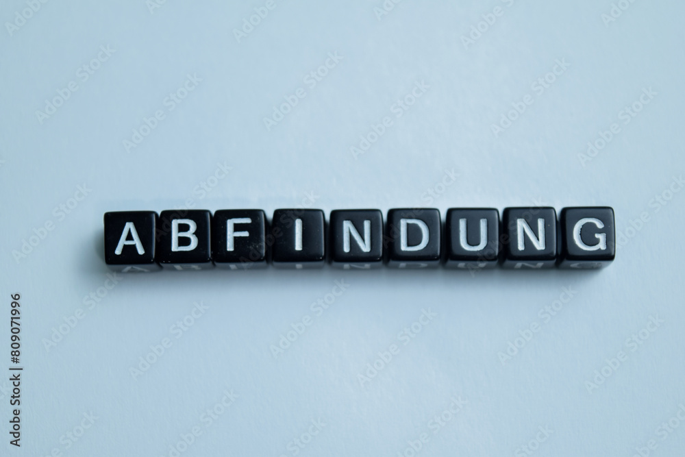 Concept of Abfindung written on wooden blocks. Cross processed image on Wooden Background Concept of Abfindung written on wooden blocks. Cross processed image on Wooden Background