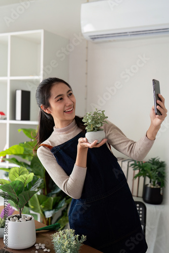 Hobby, asian young woman using mobile phone taking photo of pot, houseplant with dirt soil on table at home