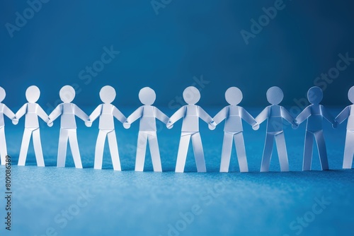 A group of paper people holding hands in a line against a blue background.