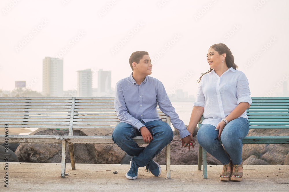 Latin woman living with her only son on Mother's Day, sitting in front of the sea Latin woman living with her only son on Mother's Day, sitting in front of the sea