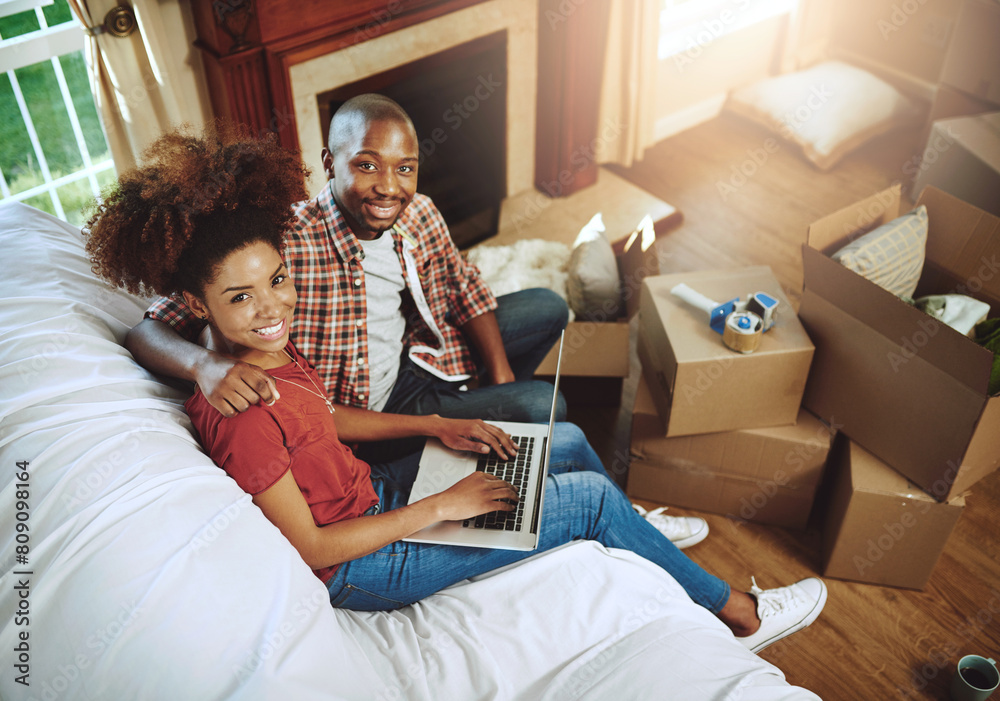 Sofa, laptop and portrait of couple in new house with smile for real estate, investment or mortgage loan. Man, woman and box with tech in high angle for marriage, relocation and planning of property