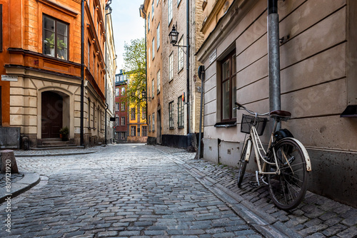 Sweden quaint cobblestone street in picturesque Gamla Stan  Stockholm s oldest neighborhood. Parked bicycles lean against the colorful plaster buildings.