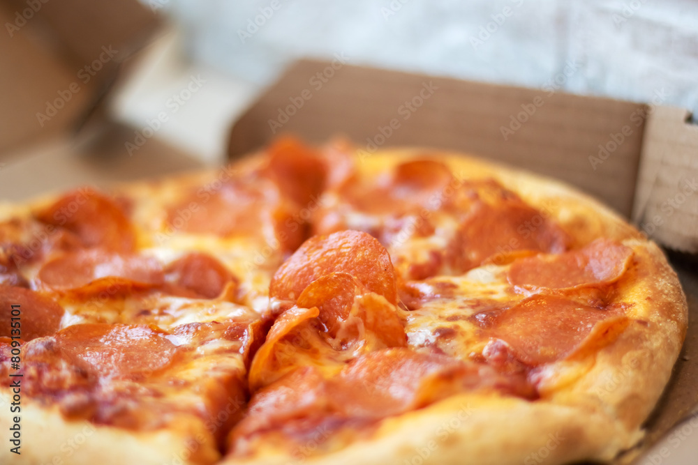 Pizza with pepperoni in a cardboard box, a staple fast food dish Pizza with pepperoni in a cardboard box, a staple fast food dish