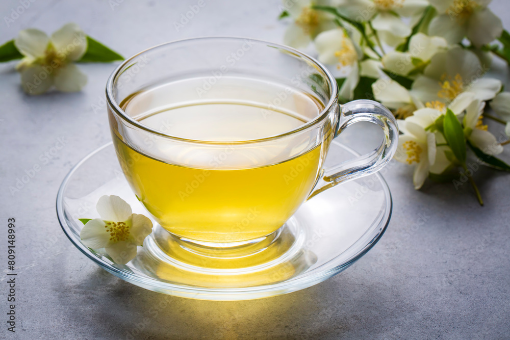 Glass cup of aromatic jasmine tea and fresh flowers Glass cup of aromatic jasmine tea and fresh flowers