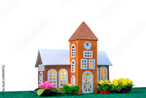 Small chapel with light in the windows surrounded by flowers