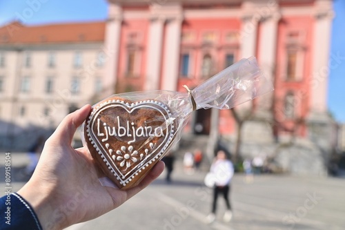 Hand Holding Heart-Shaped Medenjaki, or Slovenian Honey Spice Cookie at Old Town of Ljubljana in Slovenia