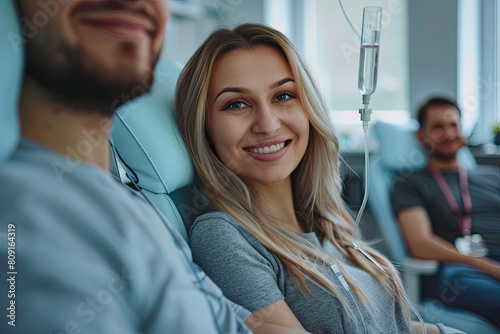 Maintenance and restoration of human immune system with vitamin IV infusion therapy. Beautiful woman with her boyfriend in modern wellness center during intravenous vitamin therapy
 photo