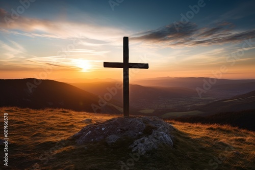 Silhouette of a cross on a hilltop at sunset © Balaraw