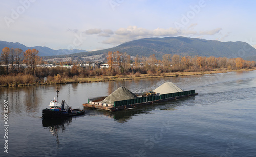 Barge loaded with gravel towed by the river tug