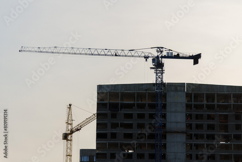 Construction cranes on top of a building under construction. The cranes are engaged in the construction work of the building. © Алексей Филатов