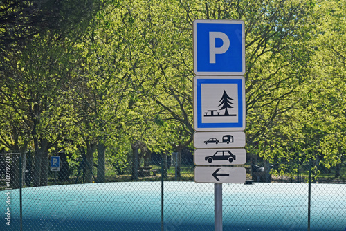 Panneau de signalisation :  parking pour caravanes, voitures, aire de piques-niques.