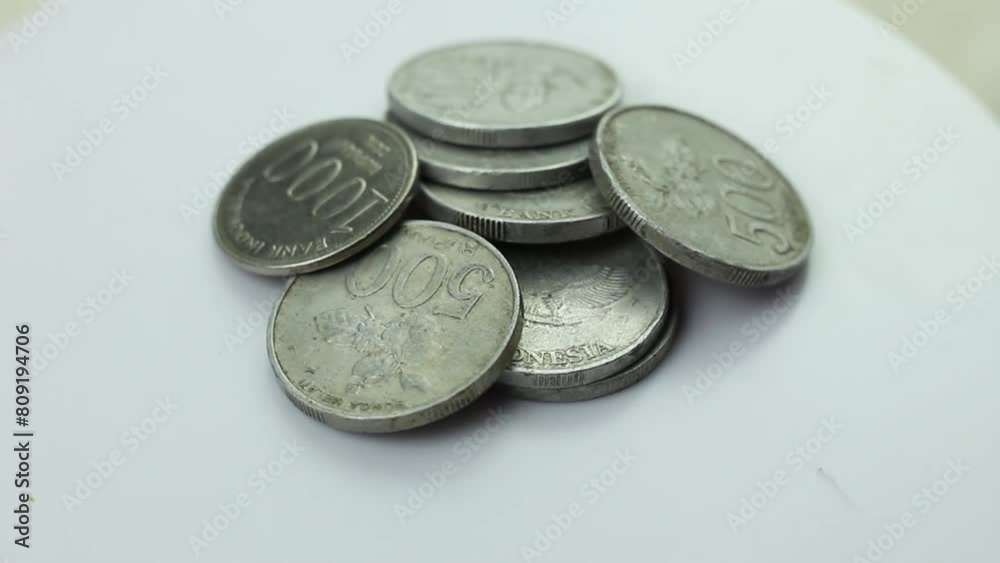 Rupiah coins stacked on a rotating display stand, the beginning of investing in wealth, saving coins of small value Rupiah coins stacked on a rotating display stand, the beginning of investing in wealth, saving coins of small value