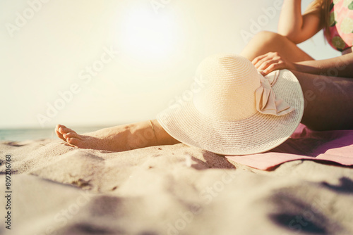 beautiful young woman sunbathing on the beach, enjoying the sun and holiday