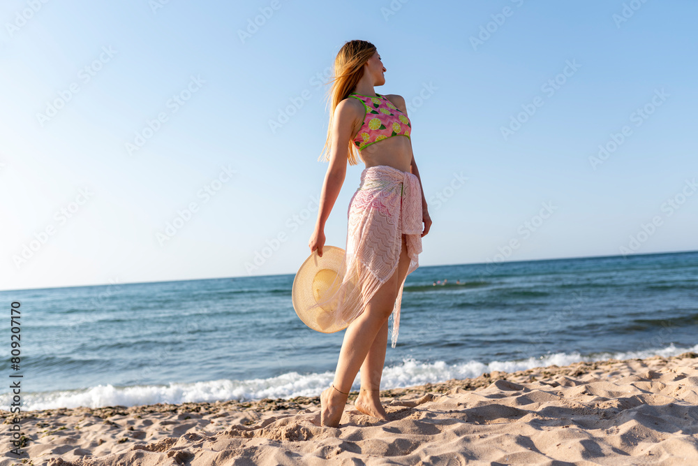 Happy woman walking on beach at sunset.Beautiful female happy relax walking on beach near sea when sunset in evening. Happy woman walking on beach at sunset.Beautiful female happy relax walking on beach near sea when sunset in evening.