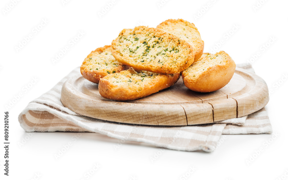 Garlic crisp bread Slices Topped With Herbs on cutting board isolated on white background. Garlic crisp bread Slices Topped With Herbs on cutting board isolated on white background.