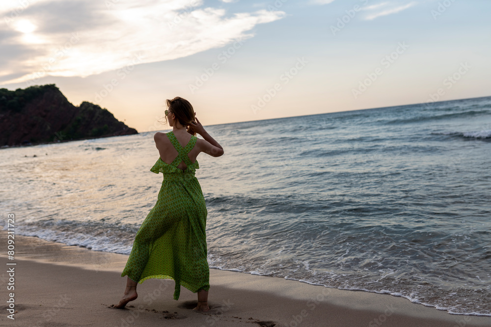 Happy woman walking on beach at sunset.Beautiful female happy relax walking on beach near sea when sunset in evening. Happy woman walking on beach at sunset.Beautiful female happy relax walking on beach near sea when sunset in evening.