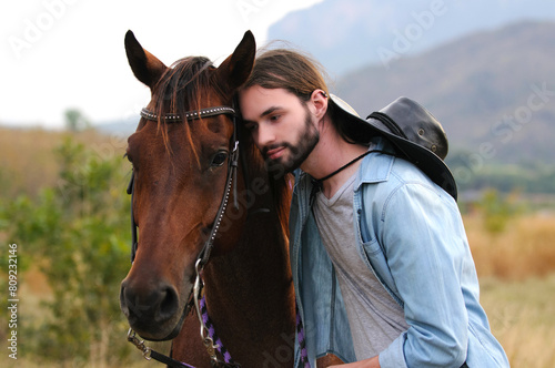 Young handsome man hugs a horse. © Kathy Kate