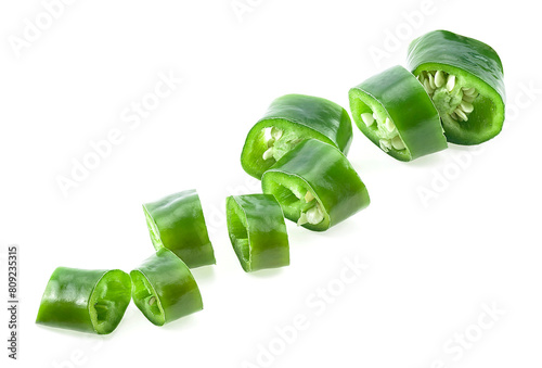 Slices of green hot chili pepper isolated on a white background. Fresh green jalapeno slices.