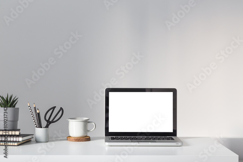 Desk with laptop, notice board and bright background.   © mallmo