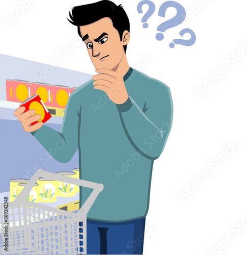 Consumer using a trolley cart in the supermarket,holding and uncertainly examining a can of product,label information,ingredients and expiration date.Product labeling