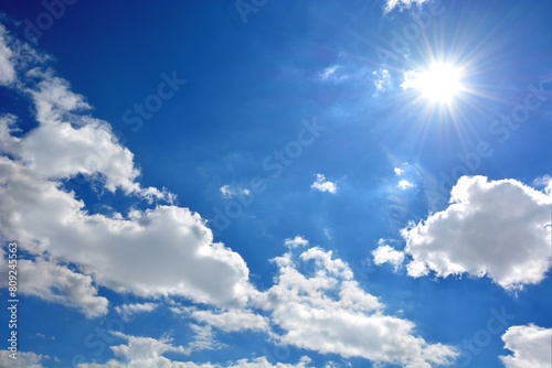 Cloudy blue sky with a shining radiant sun