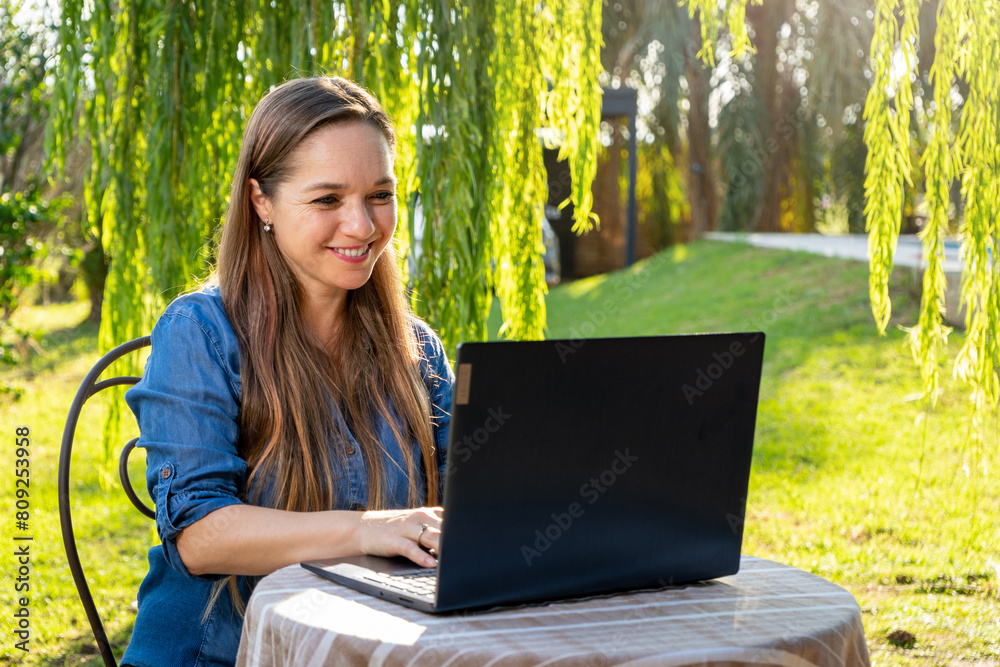 Mujer feliz trabajando con su laptop en exteriores Mujer feliz trabajando con su laptop en exteriores
