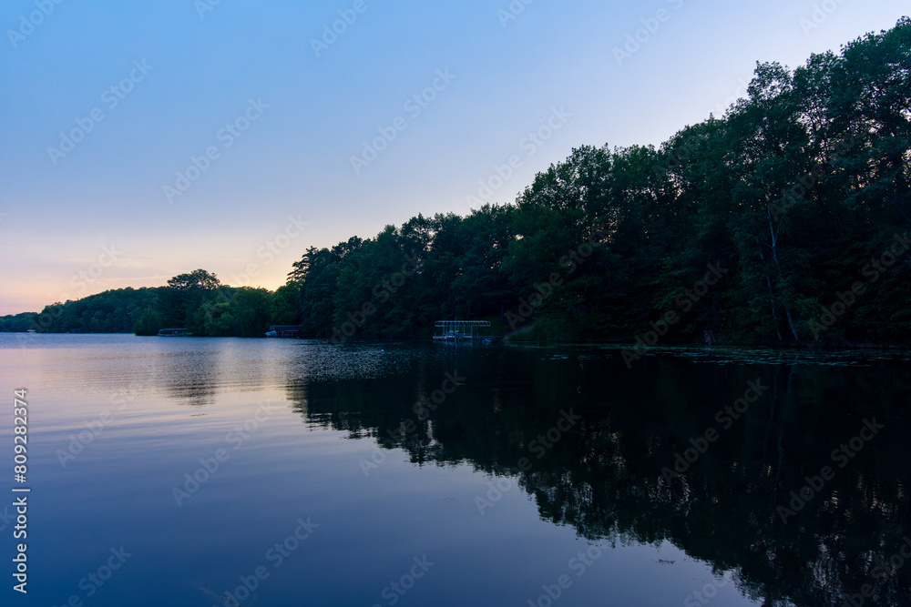 Looking onto a calm Wisconsin lake in the evening as the sun goes down.