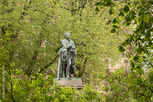 bronze staue of the writer Esaias Tegnér in a green foliage