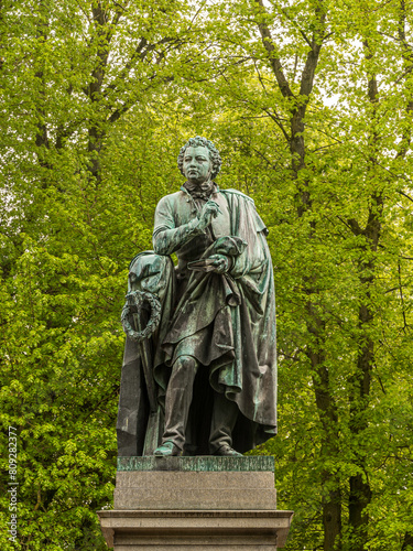 Obraz na płótnie bronze staue of the writer Esaias Tegnér against a green foliage at Lundagård w salonie