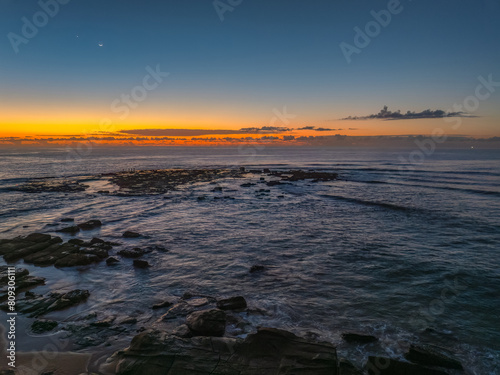 Dawn over the sea and rocks with clear skies