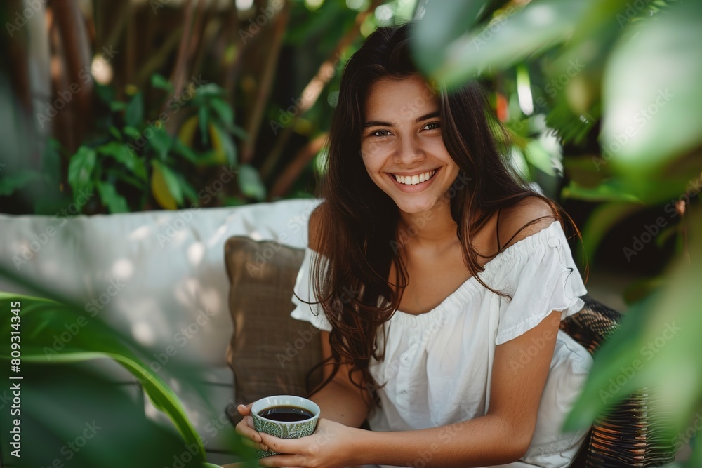 Portrait of happy young woman sitting on couch in garden Portrait of happy young woman sitting on couch in garden
