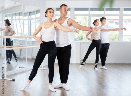 Young man and young woman dancers rehearsing pair ballet in studio