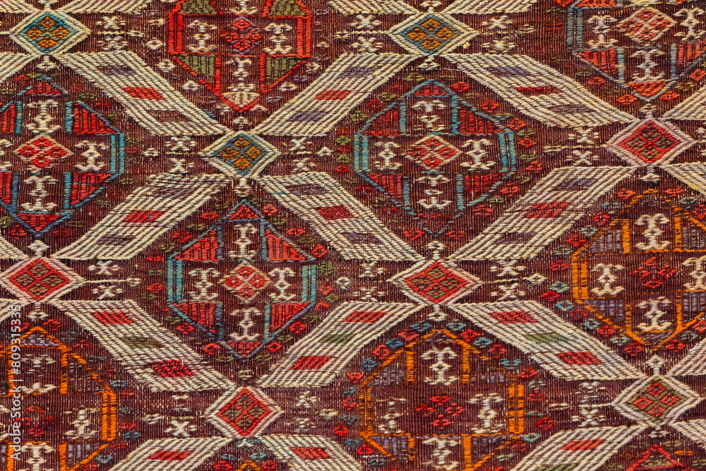Old Turkish carpet, geometric and tribal patterns in red, white, and dark tones, decor and cultural themes. Istanbul, Turkiye (Turkey)