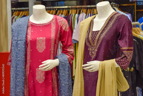 Set of saris displayed on different family mannequins at luxury shop, New Delhi