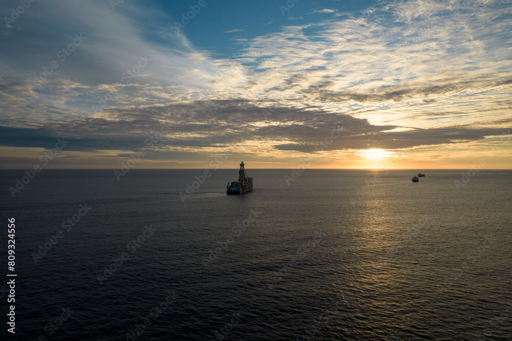 barco petrolero navegando hacia el horizonte en un atardecer