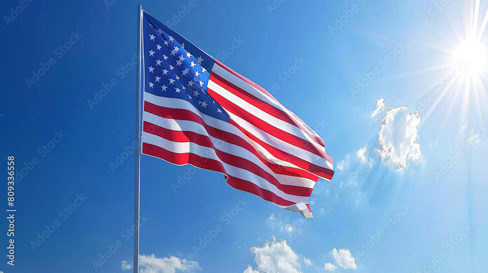 Fototapeta premium The American flag proudly waves against a vivid blue sky with the sun shining brightly, symbolizing freedom and patriotism.