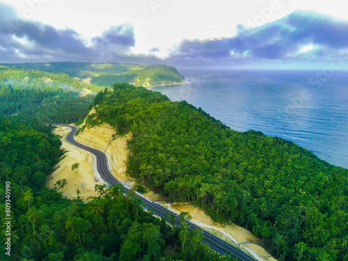 a curvy coastal road snaking along a bright blue ocean. photo
