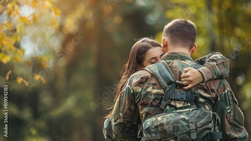 Two people embracing in camouflage, likely military, forest setting photo