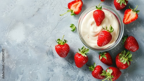 Strawberries surrounding bowl of cream on textured surface