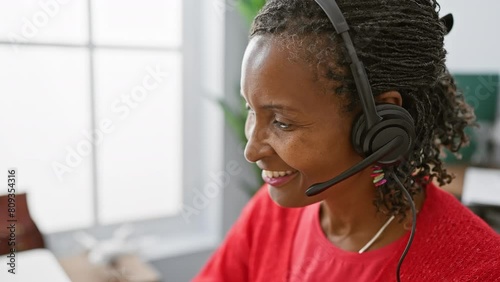 African woman smiling in office wearing headset for customer service support. photo