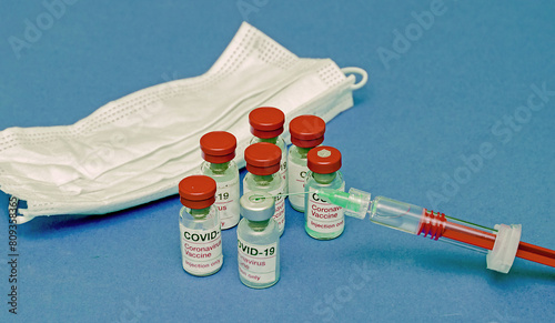 Covid-19 vaccine glass vials and full plastic syringe with sharp needle © Tatty