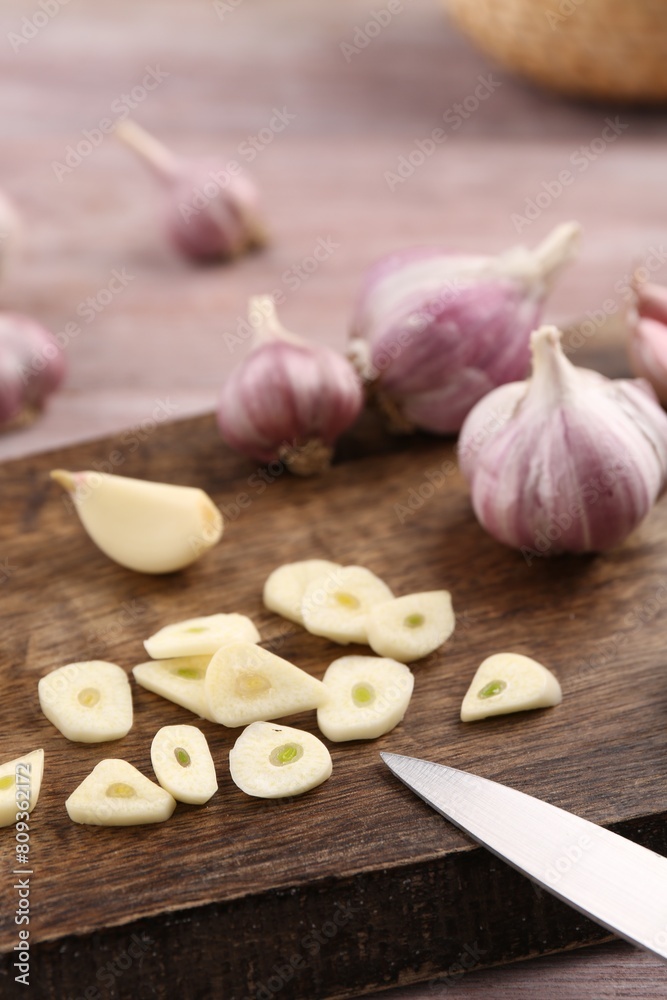 Fresh garlic and knife on table, closeup Fresh garlic and knife on table, closeup