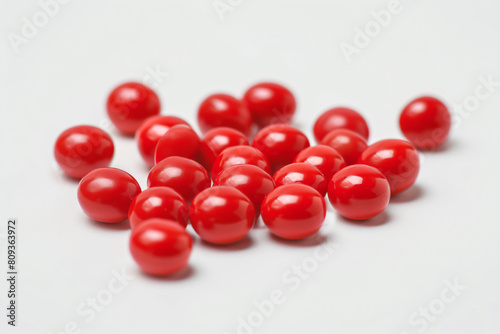 a pile of red cherry candis on a white surface photo