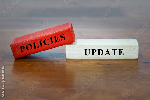 POLICIES UPDATE - text on wooden block.